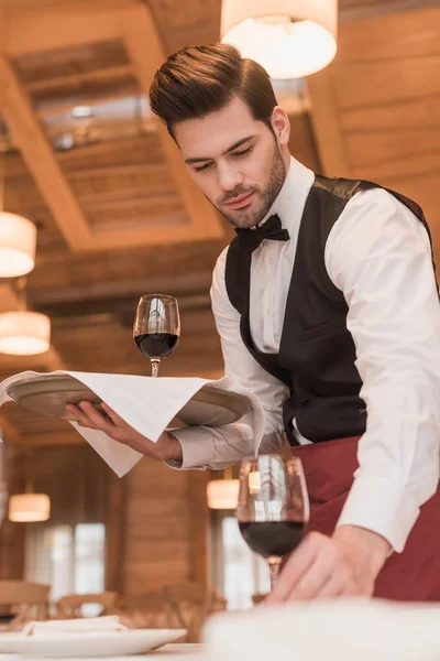 Camarero sirviendo gafas de vino en la mesa — Foto de Stock