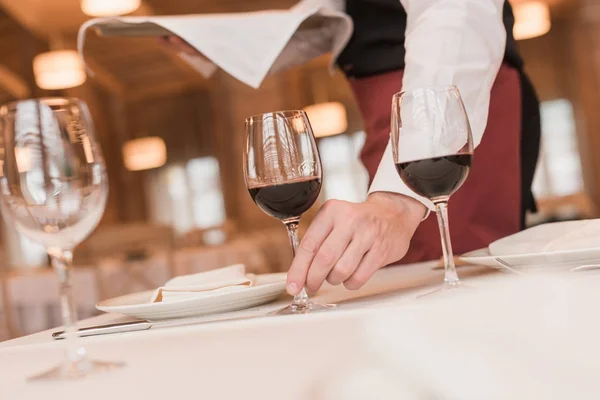 Camarero sirviendo gafas de vino en la mesa — Foto de Stock