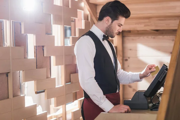 Waiter standing at cash register — Stock Photo, Image