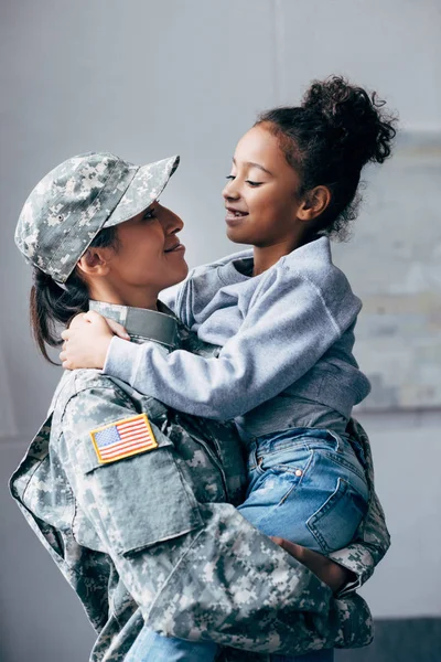 Soldat som holder datter i armene. – stockfoto