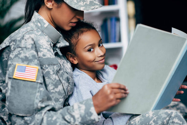 daughter and female soldier reading book