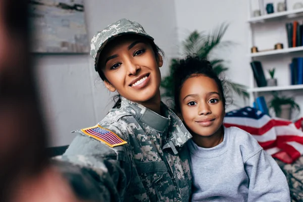 Дочь и солдат делают селфи — стоковое фото