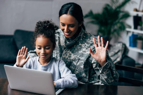 妇女在军用制服和女儿与膝上型电脑 — 图库照片