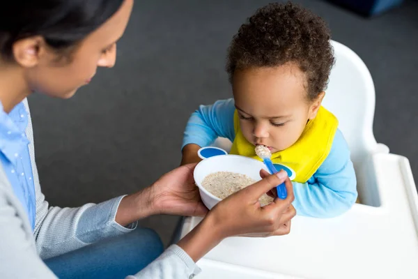 Mère nourrissant son fils avec du porridge — Photo