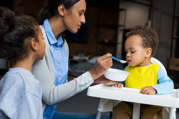 Mutter und Tochter füttern Baby — Stockfoto