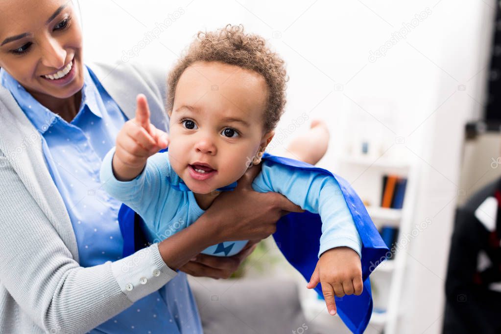 mother holding son in superhero costume