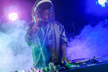 DJ in headphones with sound mixer clipart