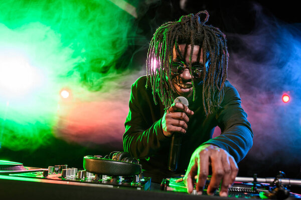 DJ with microphone and sound mixer 