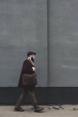 man in stylish clothing walking on street clipart