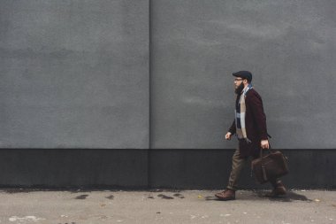 man in stylish clothing walking on street clipart