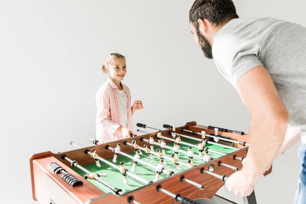 father and daughter playing foosball