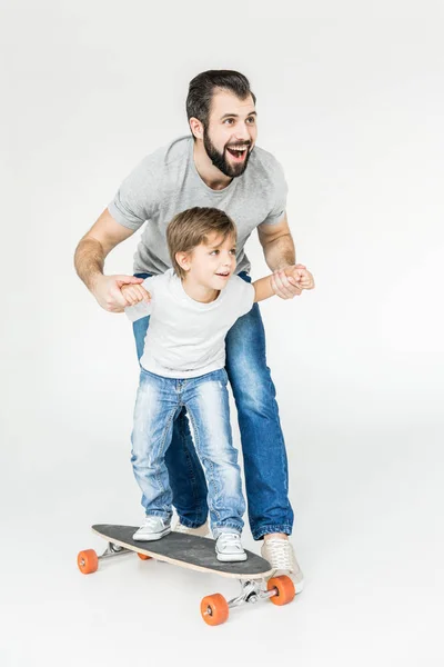 Far och son med skateboard — Stockfoto