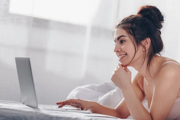 Chica usando portátil en la cama — Foto de Stock