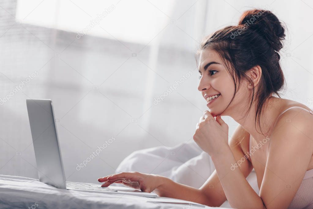 girl using laptop in bed 