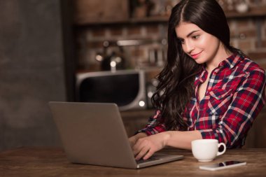 Dizüstü bilgisayar, akıllı telefon ve kahve ile kız