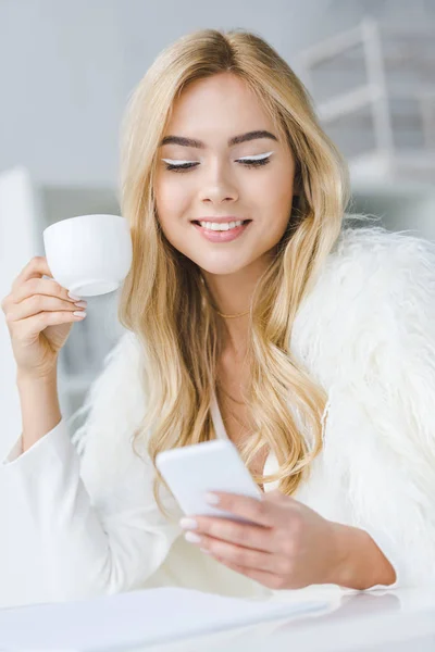 Woman with smartphone and coffee — Free Stock Photo