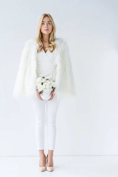 Mujer en abrigo de piel con flores blancas — Foto de Stock