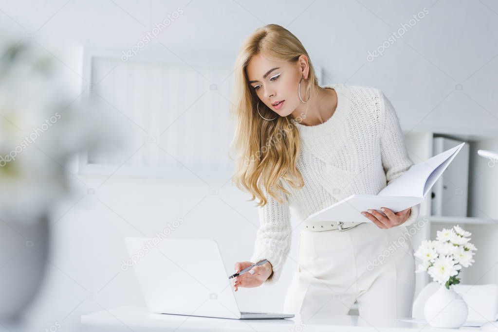 businesswoman with paperwork and laptop