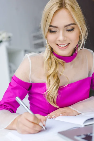 Businesswoman writing in papers — Stock Photo, Image