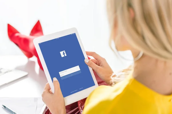 Kobieta za pomocą tabletu z facebook — Zdjęcie stockowe