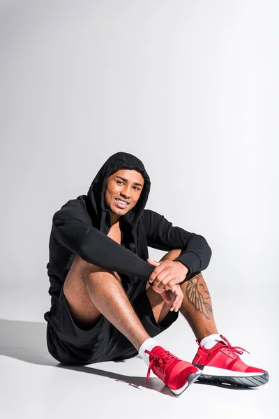 Knappe Jonge Afro Amerikaanse Sportman Hoodie Zitten Lachend Camera Grijs — Gratis stockfoto