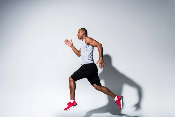 Visão Lateral Jovem Esportista Afro Americano Correndo Cinza — Fotografia de Stock