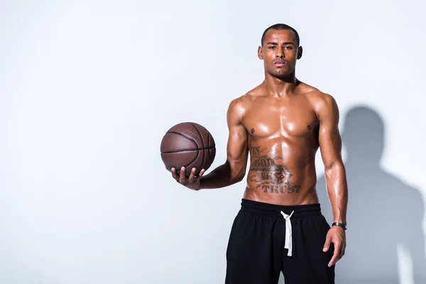 运动赤裸的非洲裔美国人男子篮球球看着在灰色的摄像头 — 图库照片