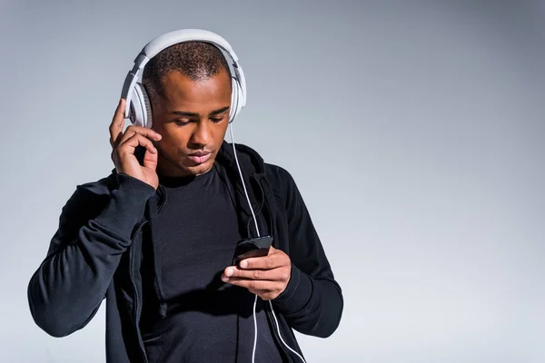 Bonito Jovem Afro Americano Homem Fones Ouvido Usando Smartphone Isolado — Fotografia de Stock