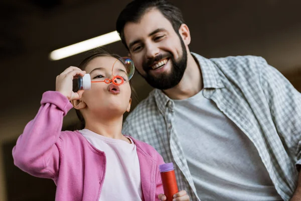 Lycklig Far Med Dotter Blåser Bubblor Hemma — Stockfoto