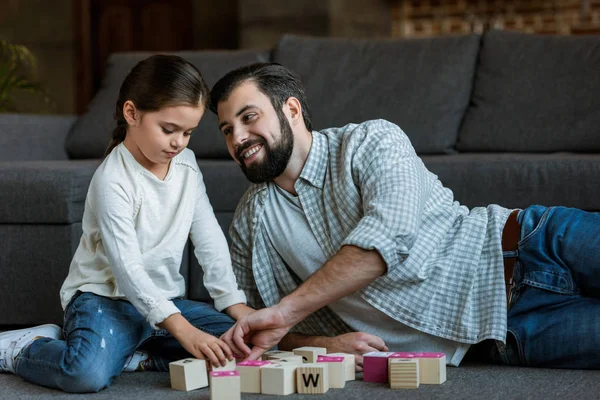 开朗的父亲与女儿在家里的字母立方体字 — 图库照片