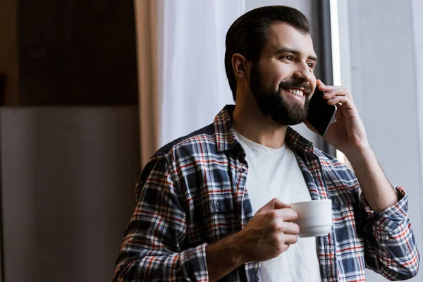 Счастливый Человек Держащий Чашку Кофе Говорящий Смартфону Дома — стоковое фото