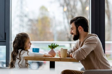 mutlu baba ve kafede oturan ve birbirine bakarak kız 