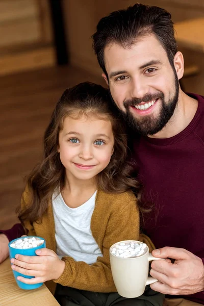 Sonrientes Padre Hija Sosteniendo Tazas Cacao Con Malvavisco Mirando Cámara —  Fotos de Stock