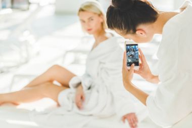 genç kadın alarak fotoğraf onun arkadaşı smartphone ile spa merkezi
