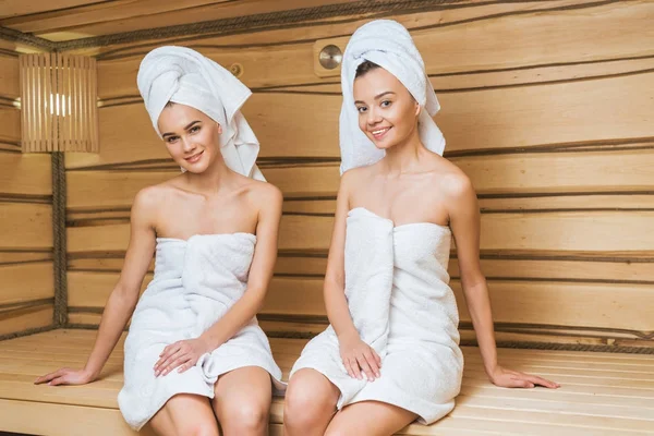 美丽的年轻妇女覆盖着浴巾在桑拿 — 图库照片