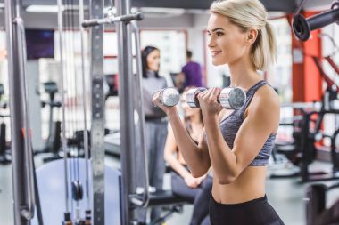spor salonunda dumbbells ile çalışma dışarı çekici genç kadın