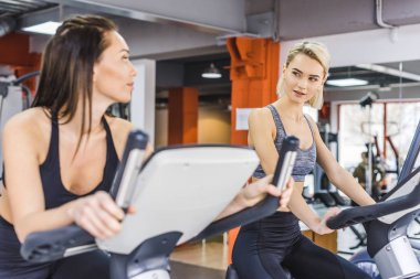 spor salonunda eliptik makineleri üzerinde çalışma dışarı güzel sportif kadınlar