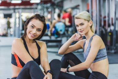 Kameraya bakarak spor salonunda modern spor giyim genç atletik bayanlar