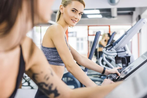 체육관에서 타원형 기계에 운동을 좋아하는 여자의 — 스톡 사진
