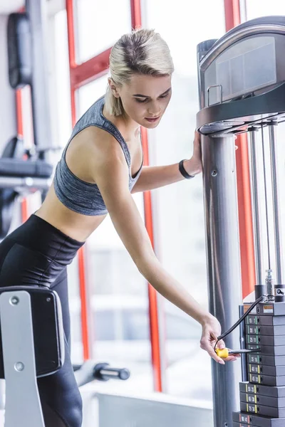 Sportive Young Woman Adding Weight Gym Machine — Free Stock Photo