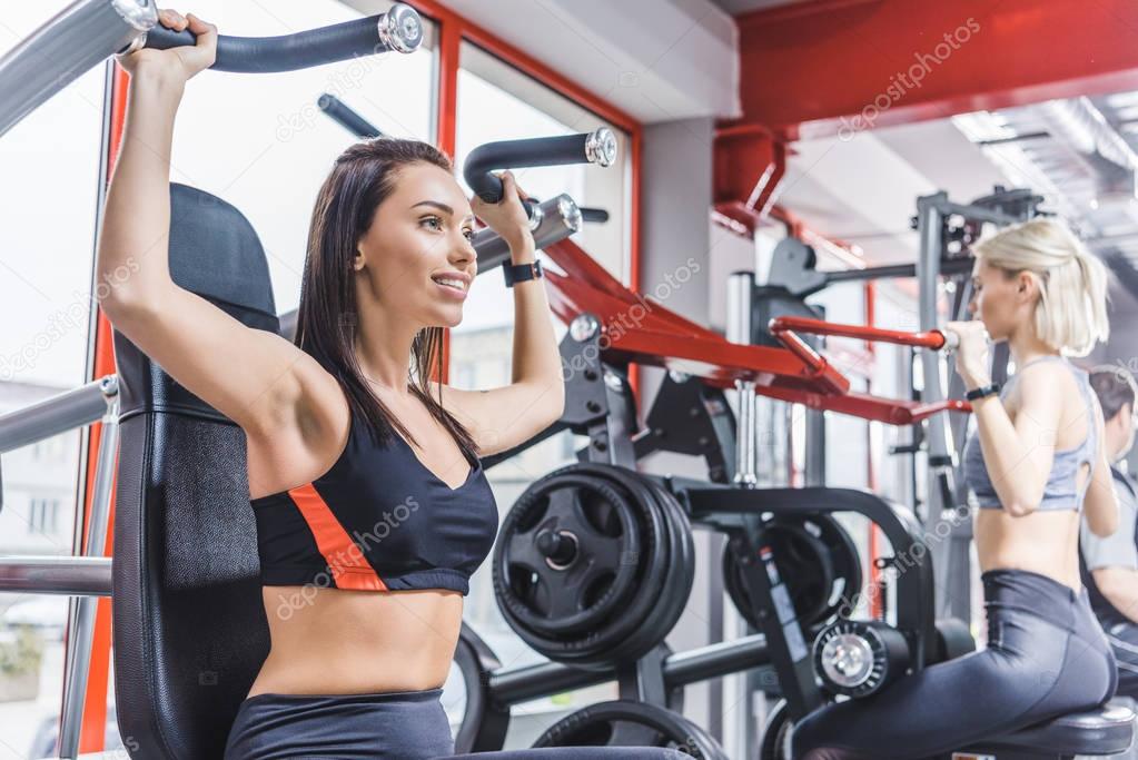 beautiful sportive women working out with gym machines