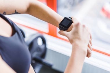 cropped shot of woman checking fitness results on smart watch clipart
