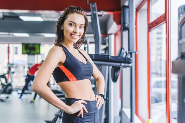 Jovem Mulher Esportiva Com Braços Akimbo Ginásio — Fotografia de Stock