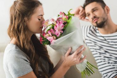 young woman with beautiful bouquet presented by boyfriend clipart