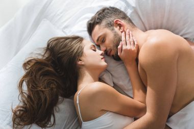 Genç çiftin yatakta sabah sarılma Üstten Görünüm