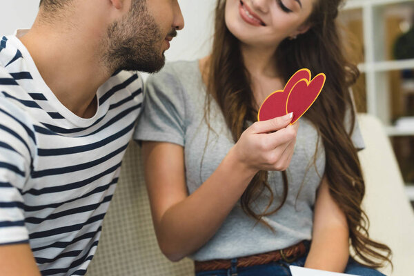 woman showing valentines day greeting card to boyfriend