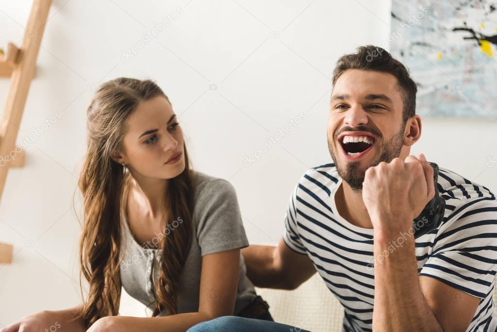 man celebrating victory in computer game over girlfriend