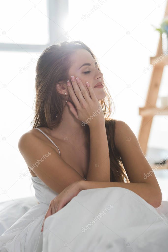 sensual young woman relaxing in bed in morning