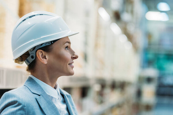 female inspector in white helmet in warehouse