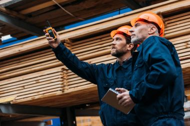 builders in helmets pointing with walkie talkie on construction clipart